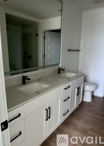 A bathroom with a sink, mirror, and toilet.