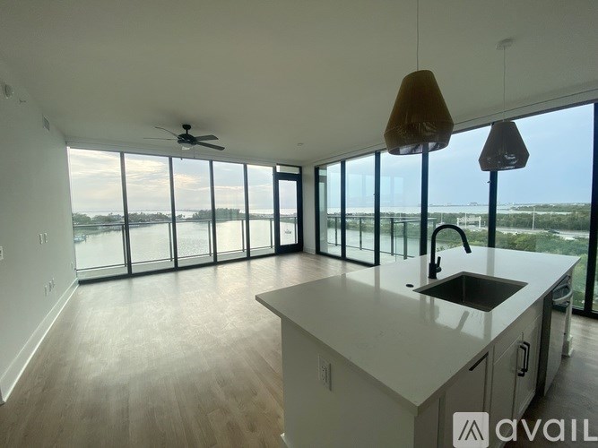 A balcony overlooks a body of water with a building and trees in the background.