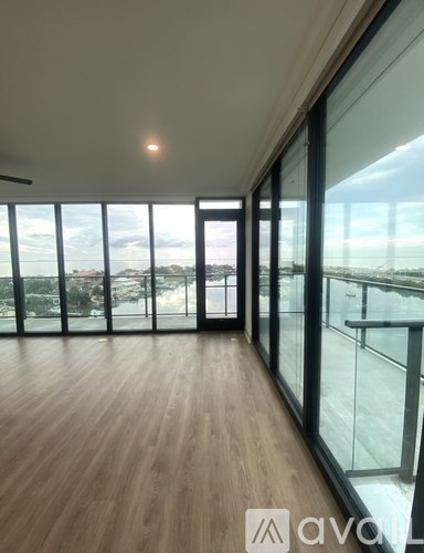 A room with wooden floors and large windows overlooking a cityscape.