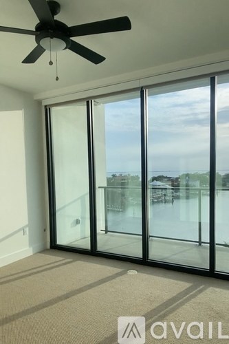 A room with a ceiling fan and sliding glass doors.