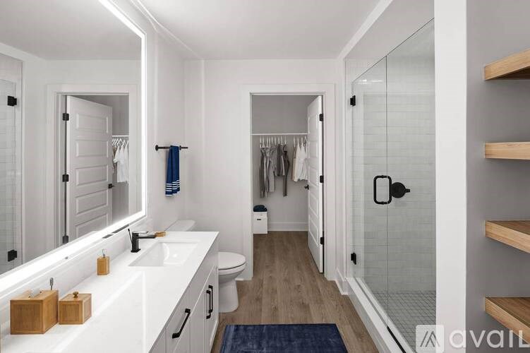 A bathroom with a white counter and a blue rug.