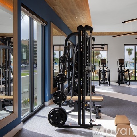 A gym with a variety of equipment including weights and machines.