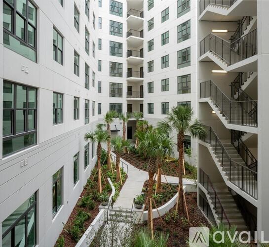 A modern building with a courtyard and palm trees.