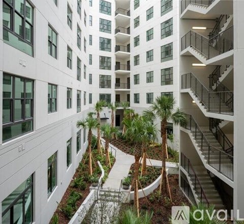 A modern building with a courtyard and palm trees.