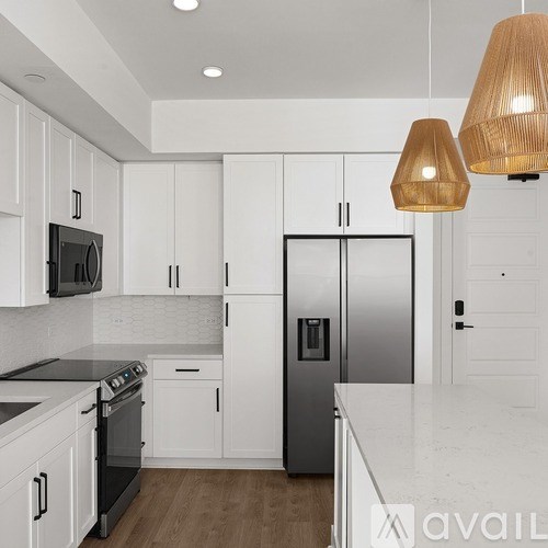 A kitchen with white cabinets and a stainless steel refrigerator.
