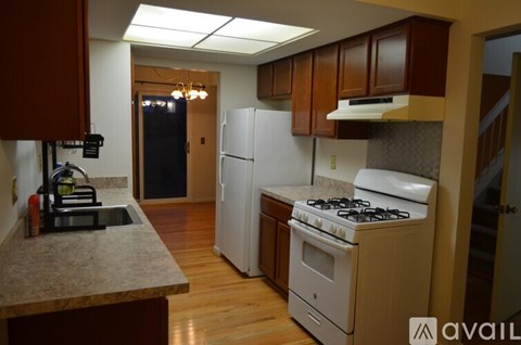 A kitchen with a white refrigerator and a white stove top oven.