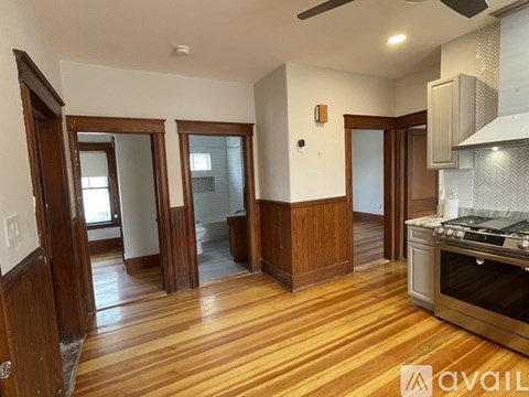 A kitchen with wooden floors and a stove top oven.