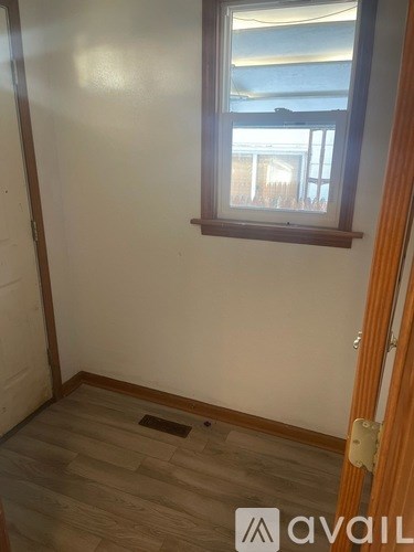 A room with a window and wooden flooring.