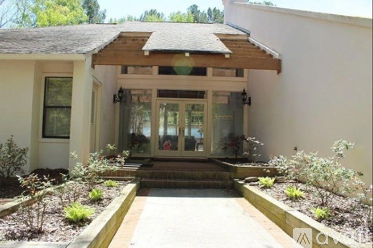A white house with a glass door and a brown roof.
