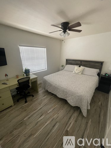 A bedroom with a bed, desk, and chair.