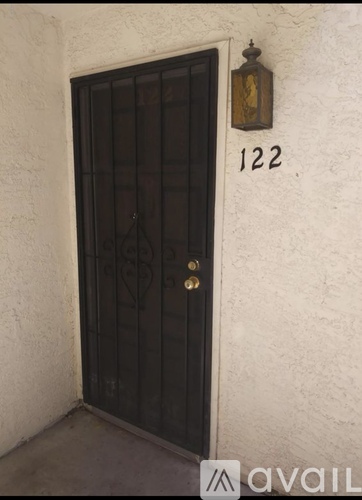 A black door with a gold handle and a number 122 above it.