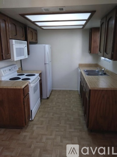 A kitchen with wooden cabinets and a white refrigerator.