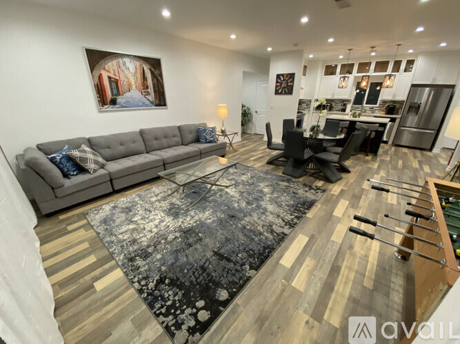 A living room with a grey sofa and a black and white rug.