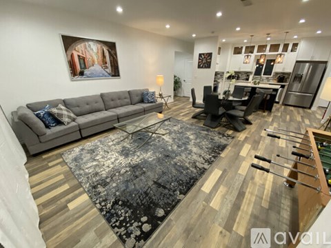 A living room with a grey sofa and a black and white rug.