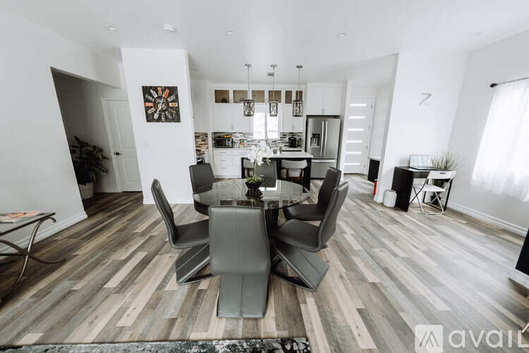 A modern dining room with a glass table and chairs.