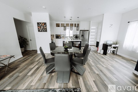A modern dining room with a glass table and chairs.