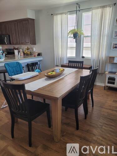 A dining room with a wooden table and chairs.