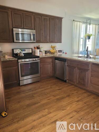 A kitchen with wooden cabinets and a stove top oven.