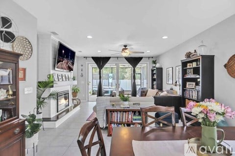 A living room with a fireplace and a television mounted on the wall.