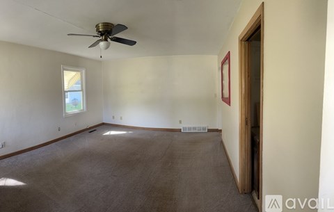 A room with a ceiling fan and a window.