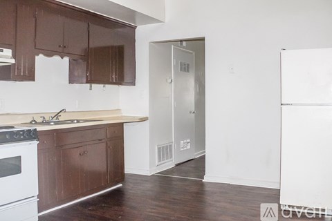 A kitchen with brown cabinets and a white stove top oven.