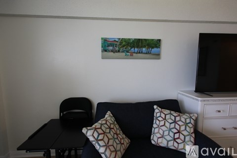 A living room with a couch, chair, and a painting on the wall.