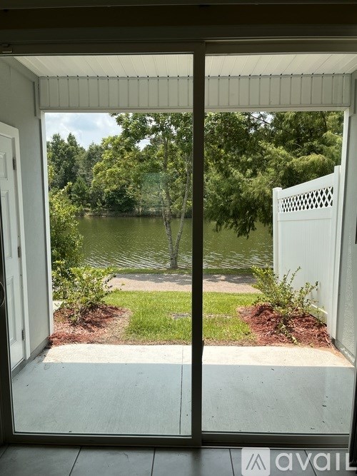 A view from a window looking out to a pond and greenery.