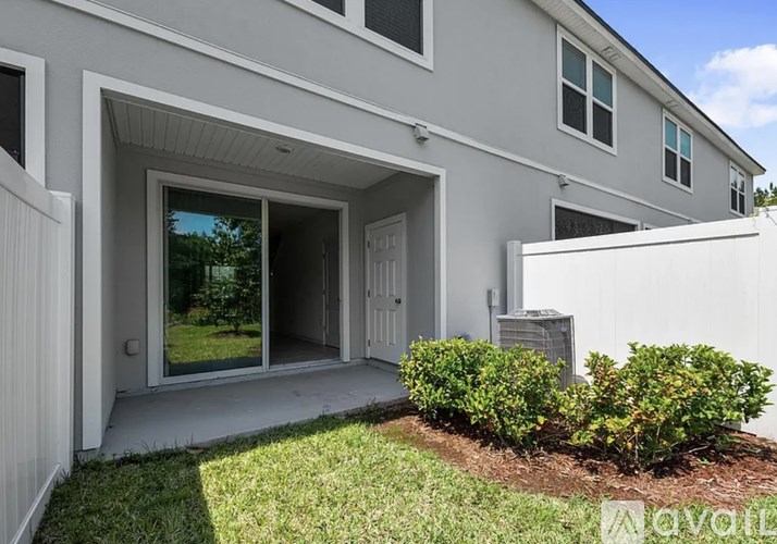 A modern house with a white exterior and a large glass door.