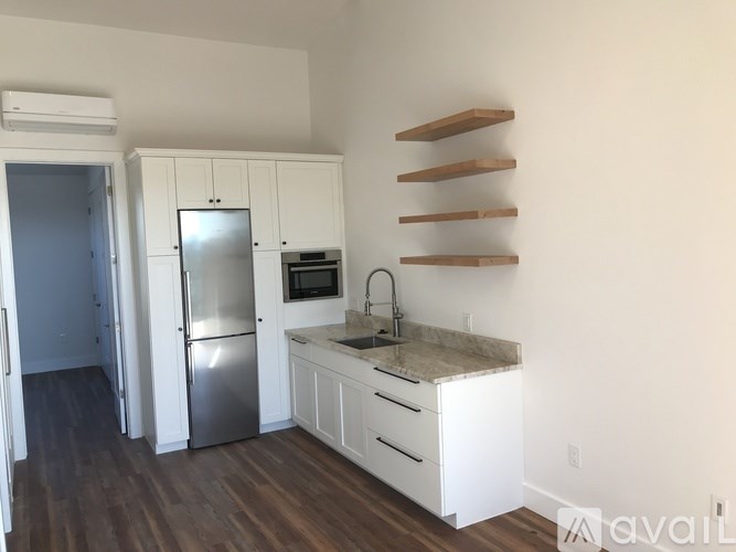 A kitchen with white cabinets and a stainless steel refrigerator.