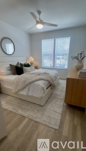 A bedroom with a large bed and a ceiling fan.