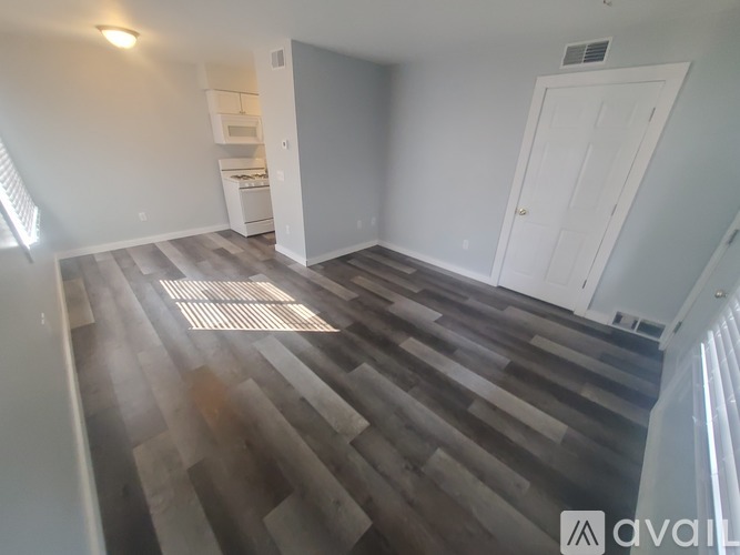 A room with wooden flooring and a white door.