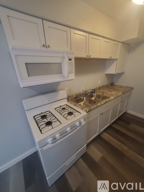 A kitchen with white appliances and cabinets.