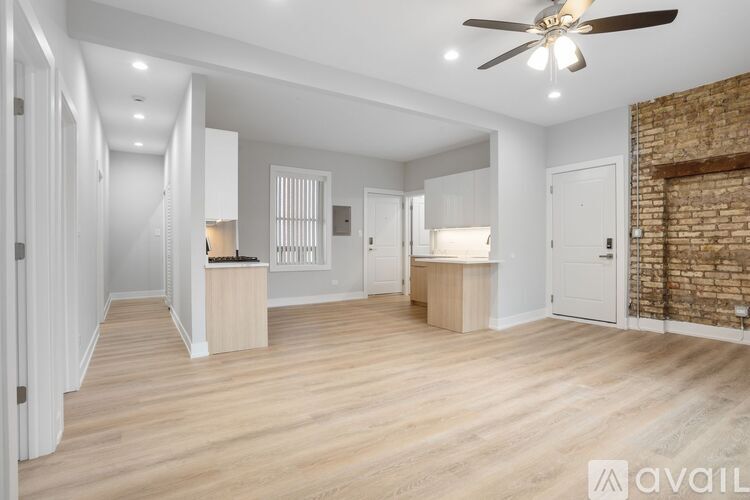 A spacious room with wooden floors and a ceiling fan.