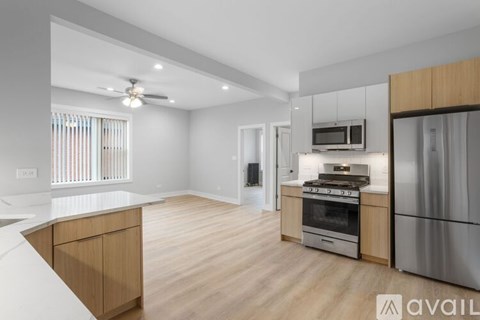 A kitchen with wooden cabinets and stainless steel appliances is available for rent.
