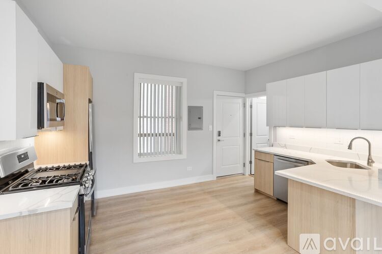 A kitchen with white cabinets and a wooden floor.