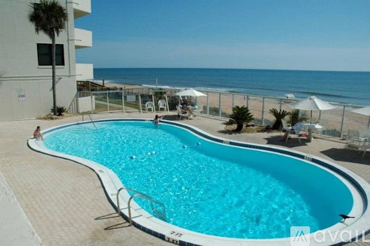 A large outdoor swimming pool with a person in the background.