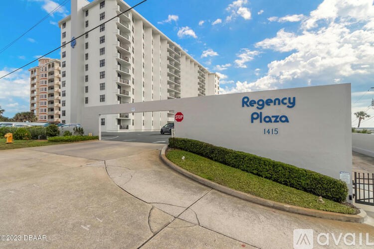 A white building with a sign that says "Regency Plaza 1415" in front of it.