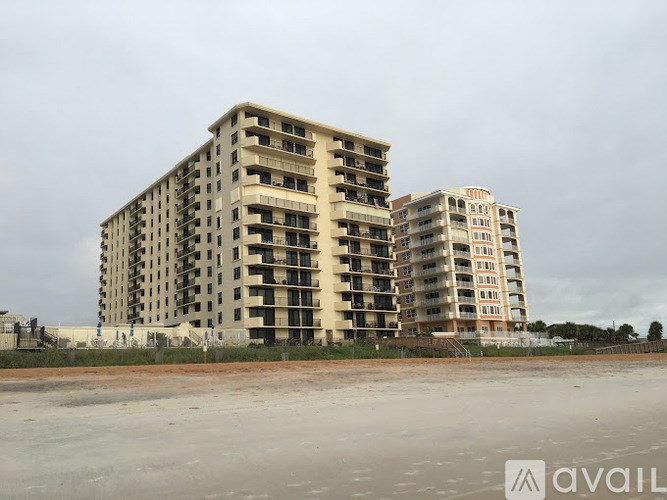 A large, unfinished apartment building sits in the middle of a construction site.