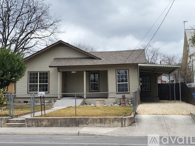 A house with a grey roof and a black fence.