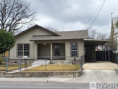 A house with a grey roof and a black fence.