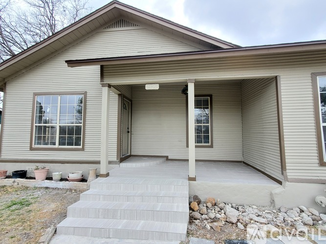 A house with a grey roof and a grey front porch.