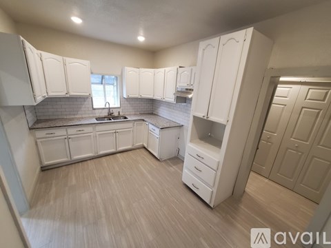 A kitchen with white cabinets and a sink.