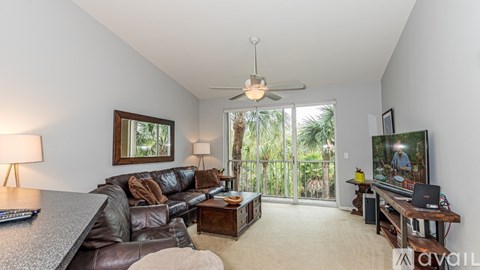 A living room with a brown leather couch and a television.