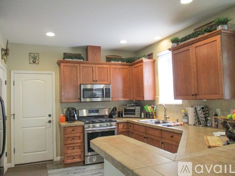 A kitchen with wooden cabinets and a stove top oven.