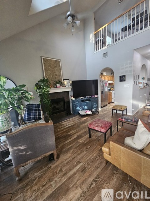 A living room with a grey sofa and a wooden floor.