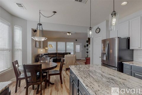 A kitchen with a table and chairs in the foreground and a refrigerator in the background.
