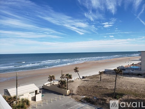 A beachfront view with a clear sky and a building with the text "AVAIL" on it.