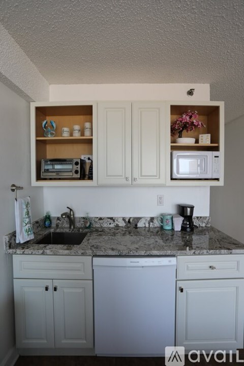 A kitchen with white cabinets and a granite countertop.