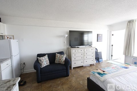 A living room with a blue couch and a white dresser.