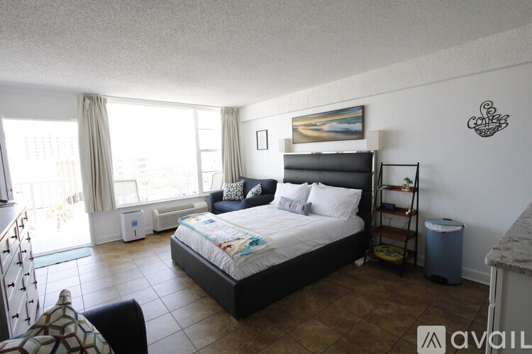 A bedroom with a large bed and a painting on the wall.